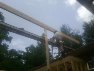 Carpenter setting a ridge beam over a new addition frame — Ice Dam Removal by Roofing Brothers in Sierra Madre