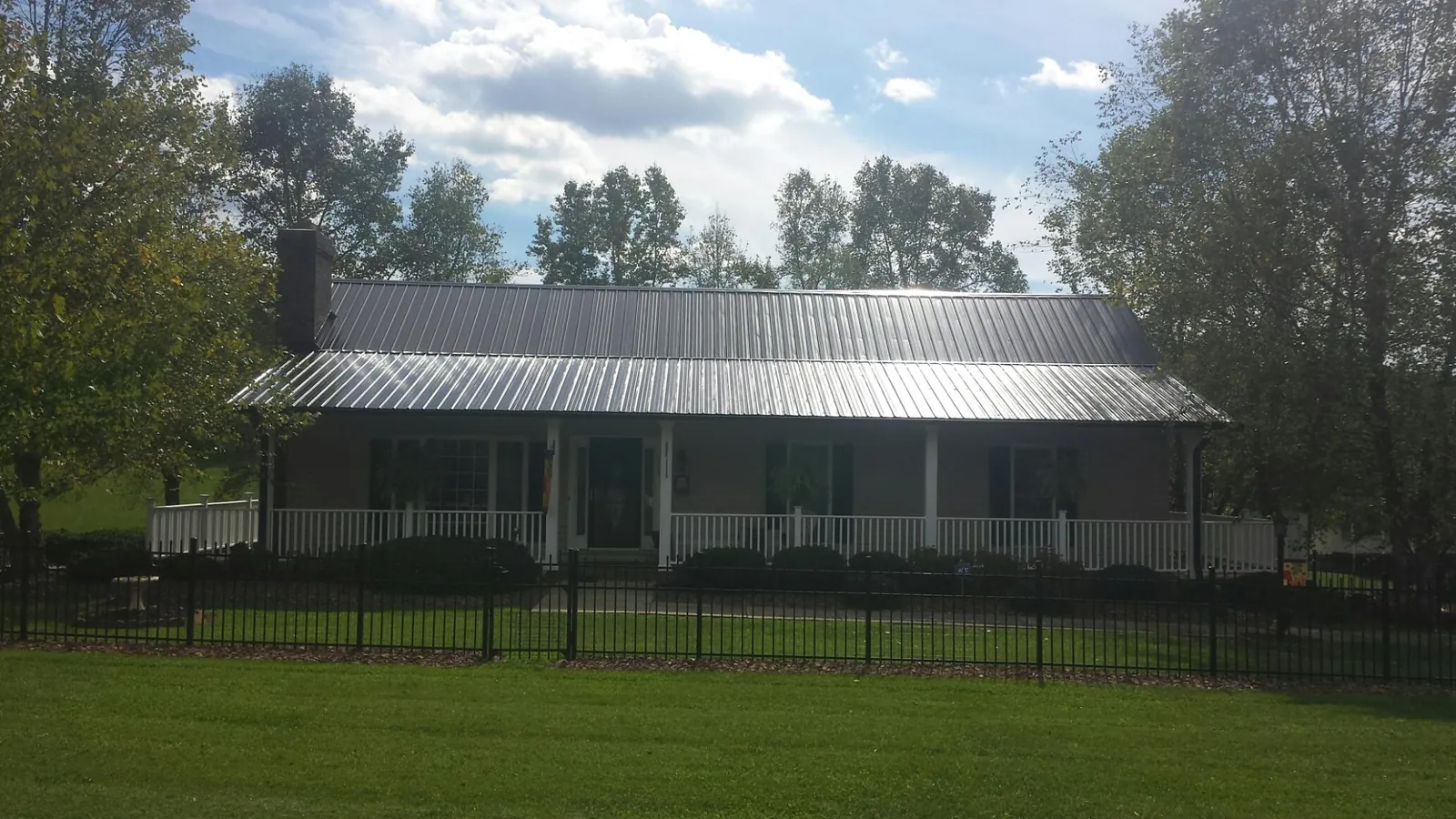Gray metal roof on a brick ranch with a full width front porch — Gutter Guard Installation work by our crew in Sierra Madre